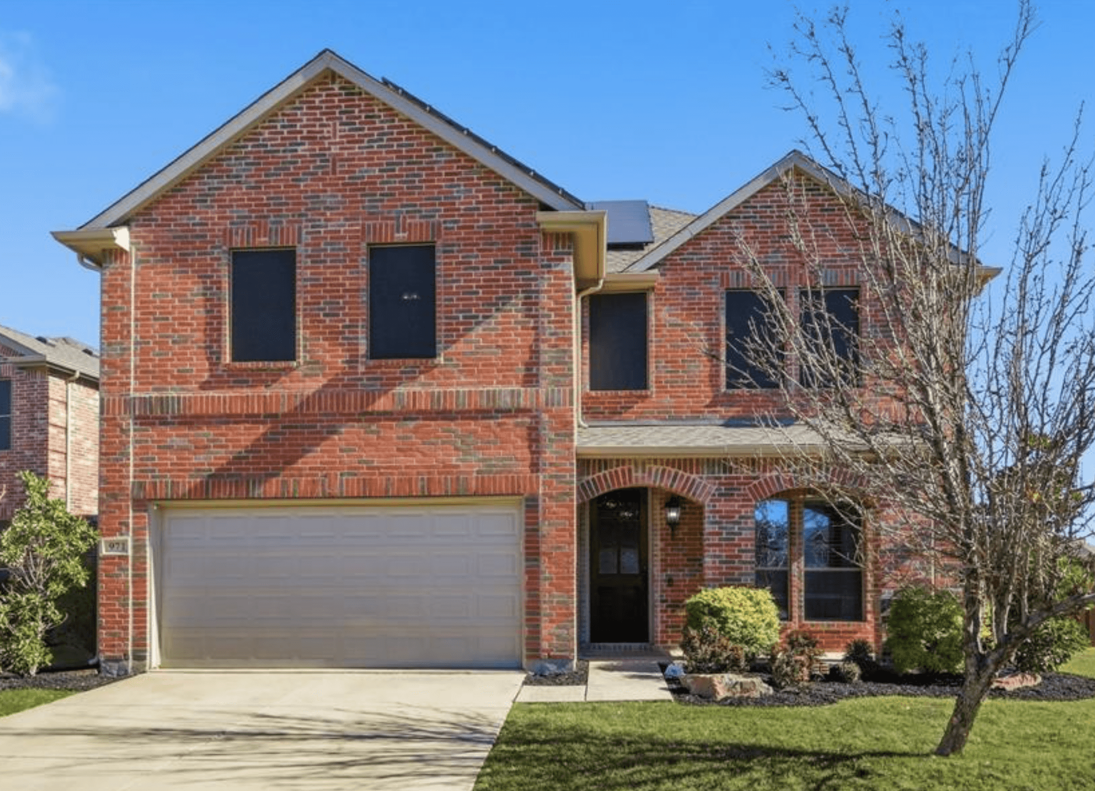 Brick house exterior before update — red brick Texas home with beige garage door and beige trim