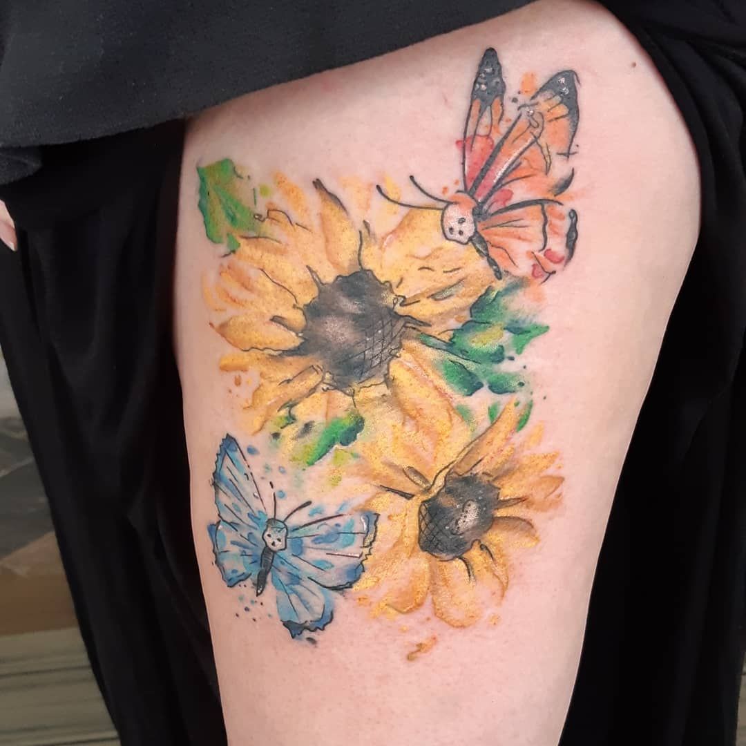 Colour watercolour sunflowers and butterflies tattoo on a thigh