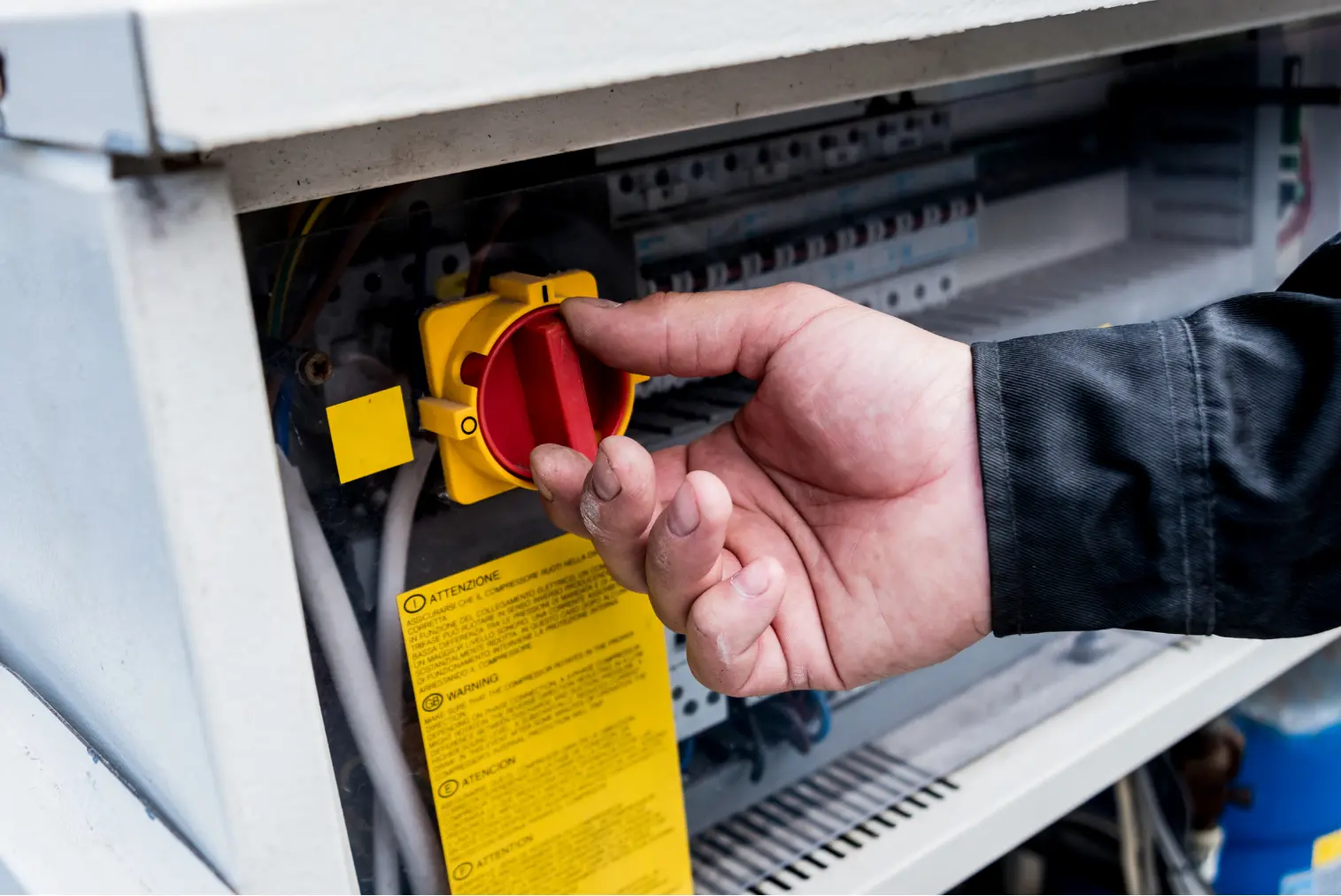 Technicien actionnant un interrupteur électrique dans un tableau