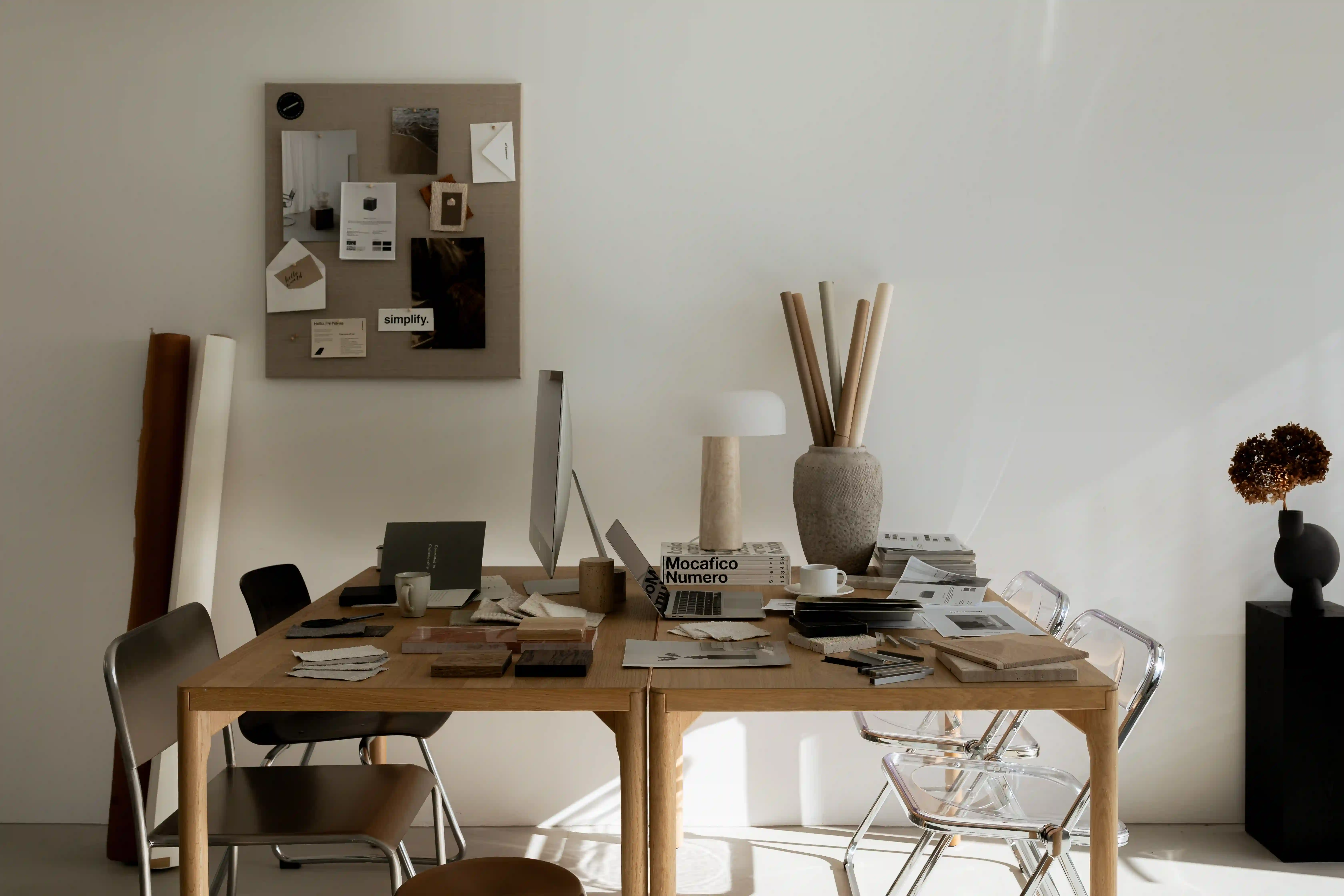 Vertical shot of a creative desk setup with architectural books and a lamp.