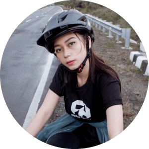 Cyclist in black shirt with helmet on mountain road.