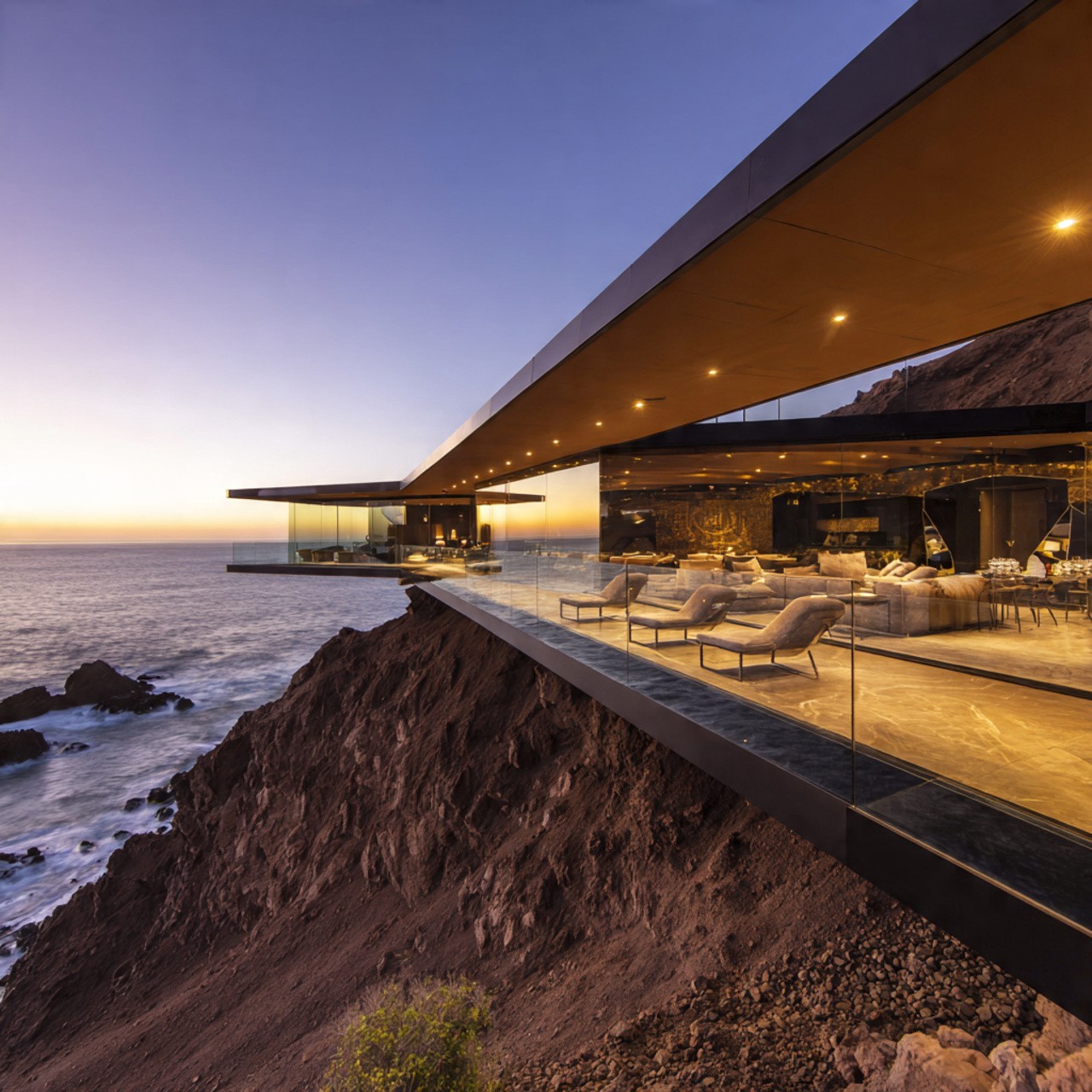 Stunning glass-walled modern house on a cliffside at sunset, overlooking the ocean. Luxurious interiors visible, creating an elegant and serene ambiance.