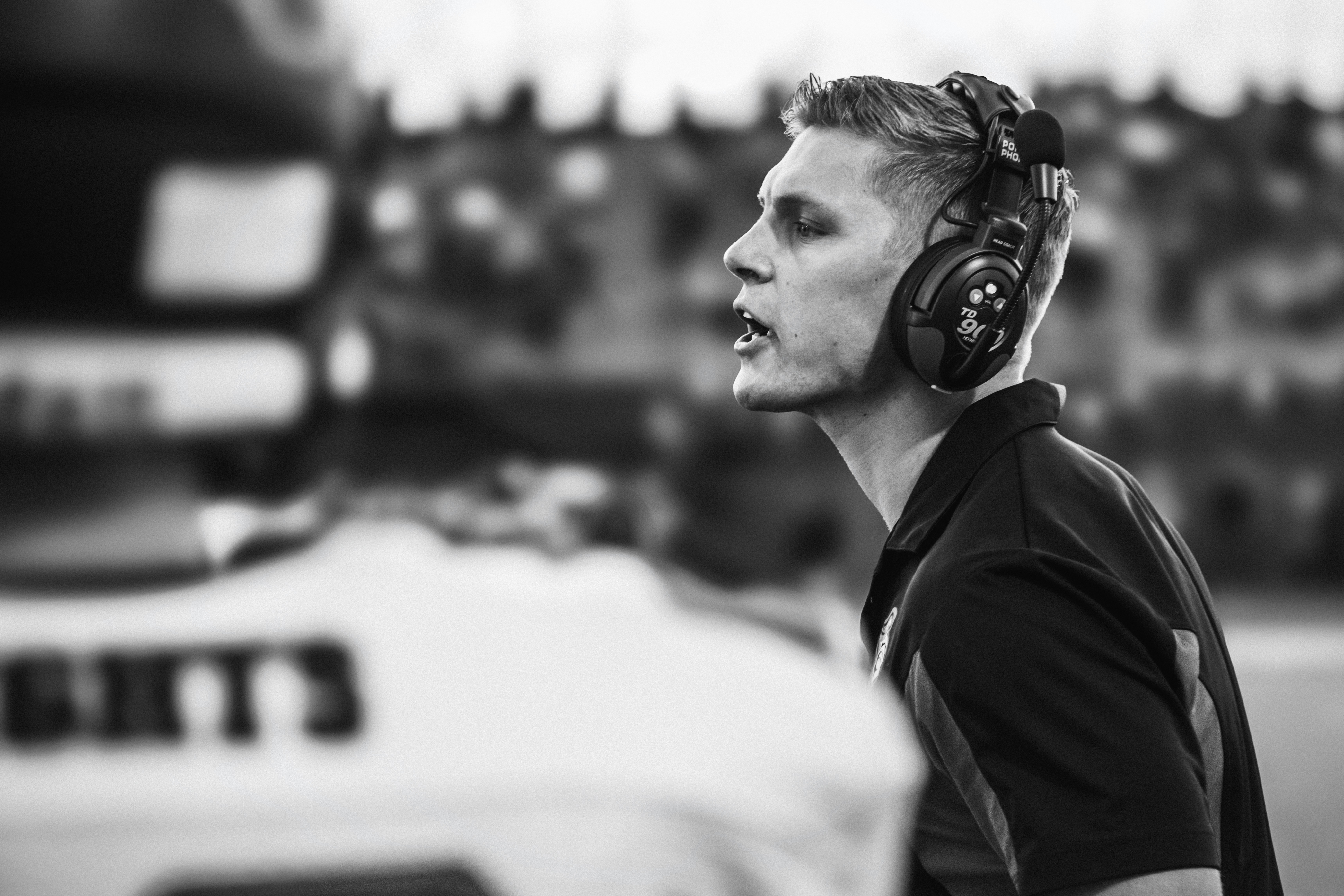 Man wearing headphones on a sports field.