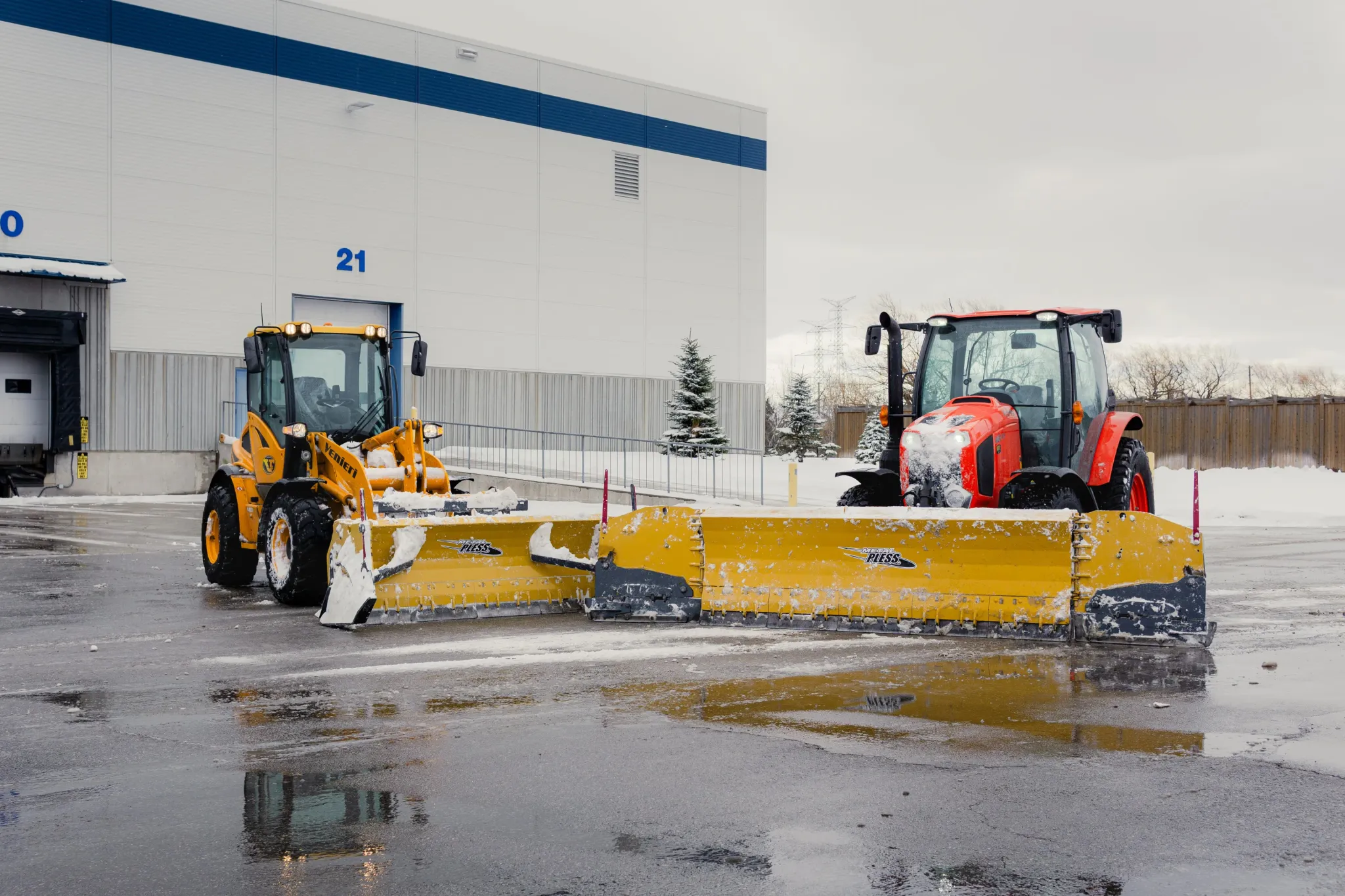 Falcons Landscaping's snow plow trucks clearing snow outside a warehouse