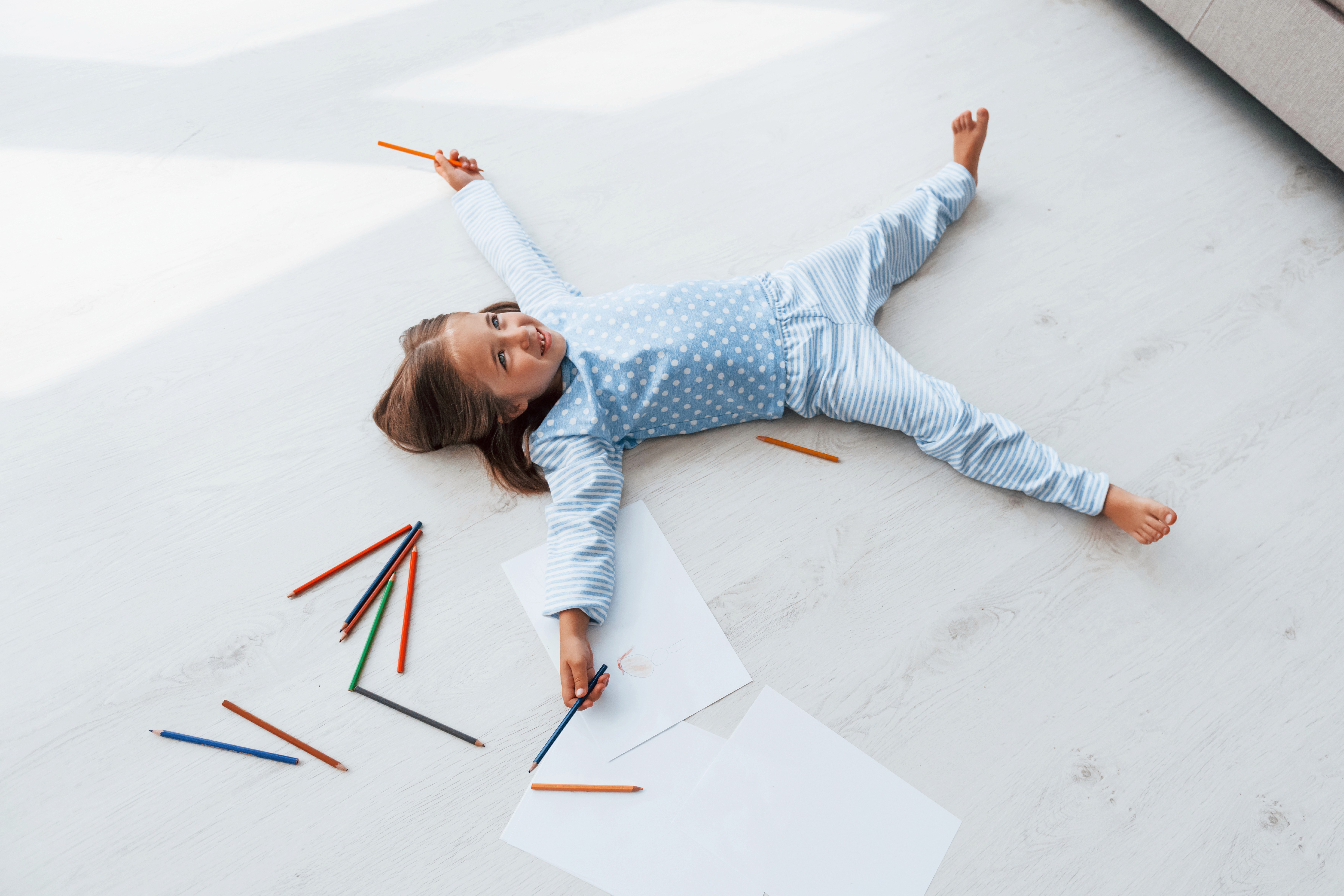 Kids drawing on the floor without worry, thanks to stain-resistant hybrid flooring that wipes clean easily.