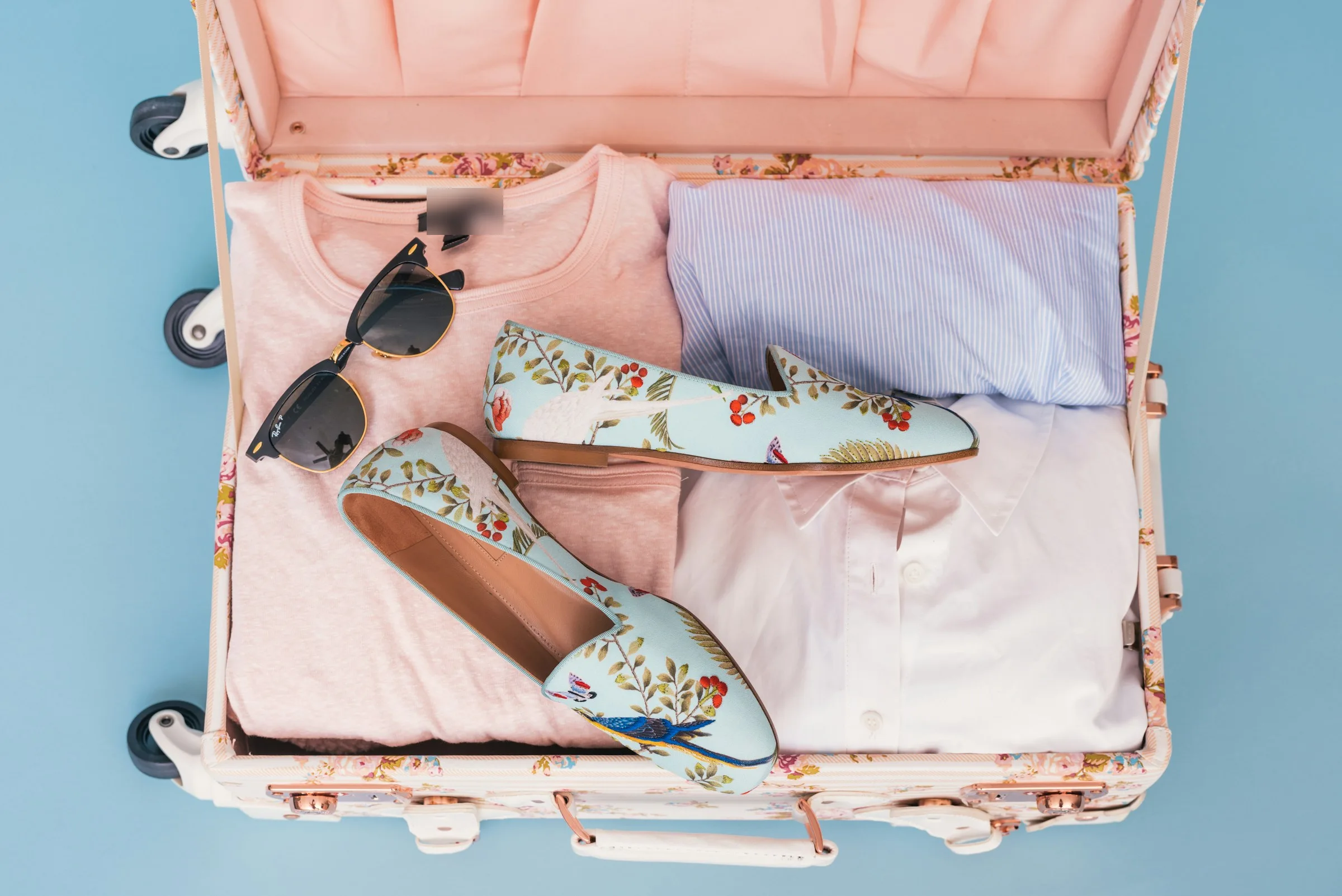 A pink suitcase packed with clothes