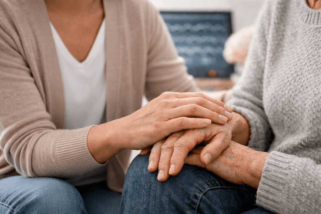 Silhouette of a researcher examining a slide under a microscope with a blue background.