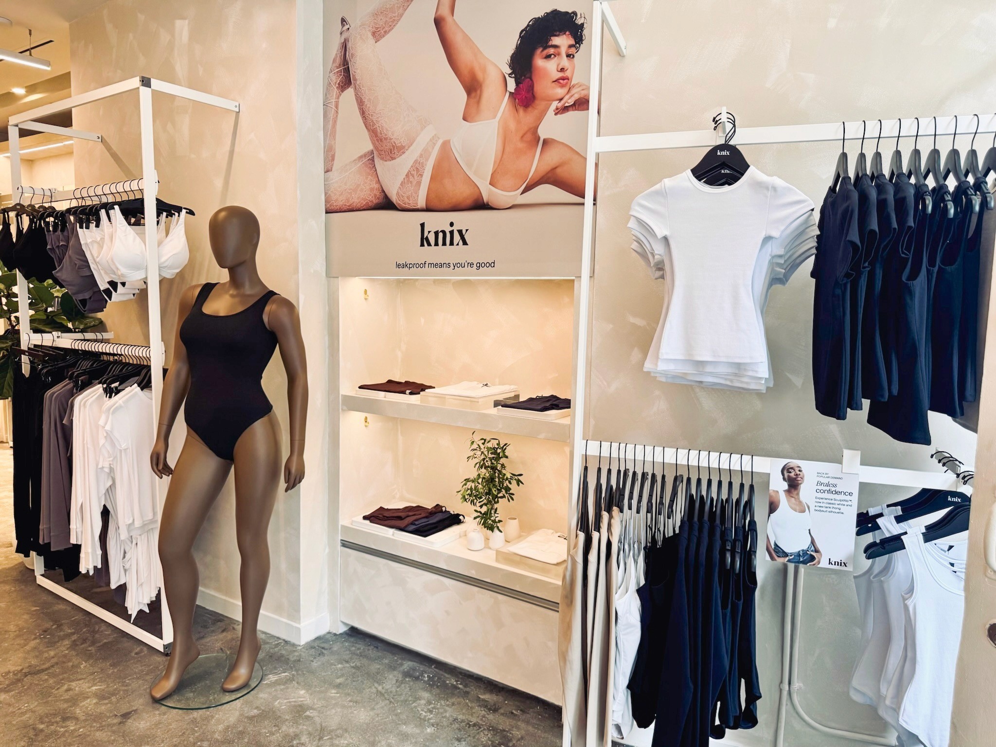 Knix store interior featuring mannequins, apparel displays, and retail merchandising graphics.