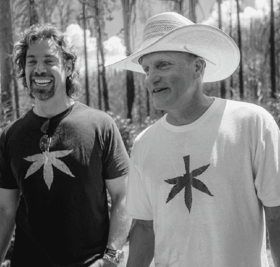 Woody Harrelson talking and laughing with his friend.