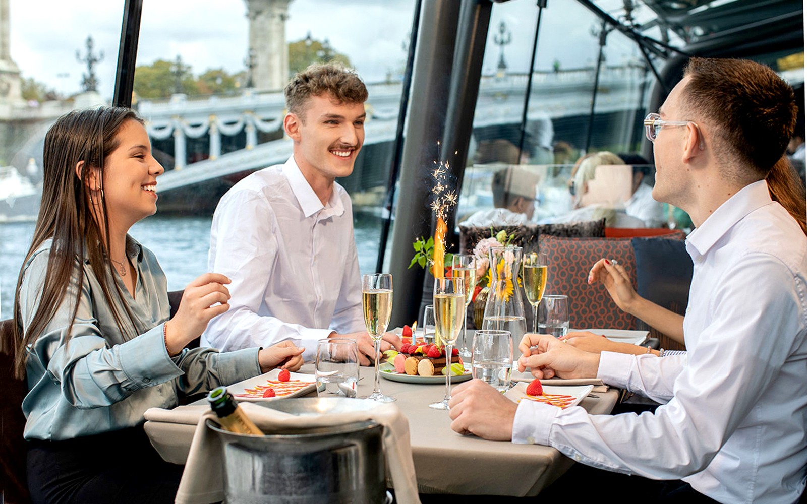 宾客在巴黎圣诞游轮上享受节日餐,同时欣赏埃菲尔铁塔美景。