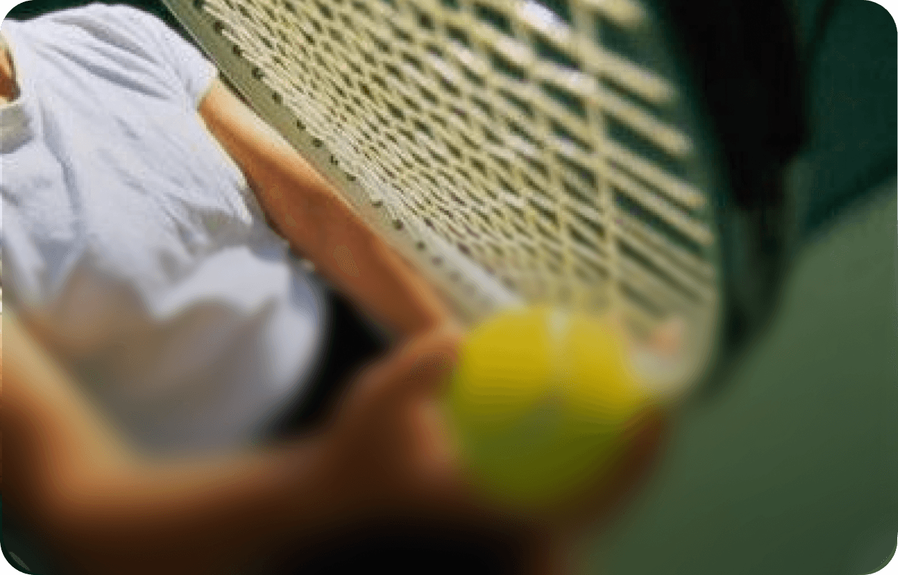 Tennis player holding a yellow tennis ball with a racket, ready to serve or return the ball.