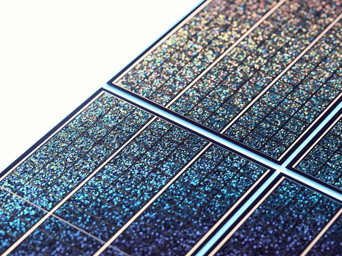 Nahaufnahme der Oberfläche eines Solarpanels, die seine strukturierten blauen und schwarzen photovoltaischen Zellen zeigt.
