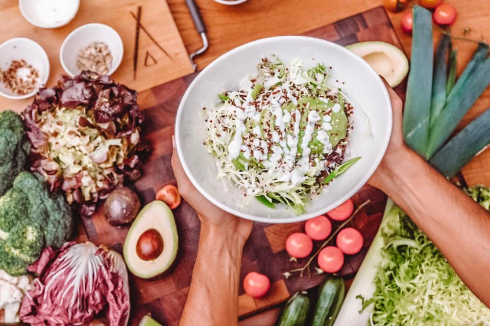 Black-and-white party photo of a smiling man in a check blazer among a crowd.