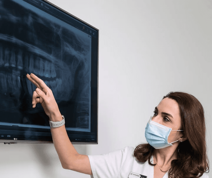 Dentist reviewing dental X-rays to diagnose gum disease and periodontitis 