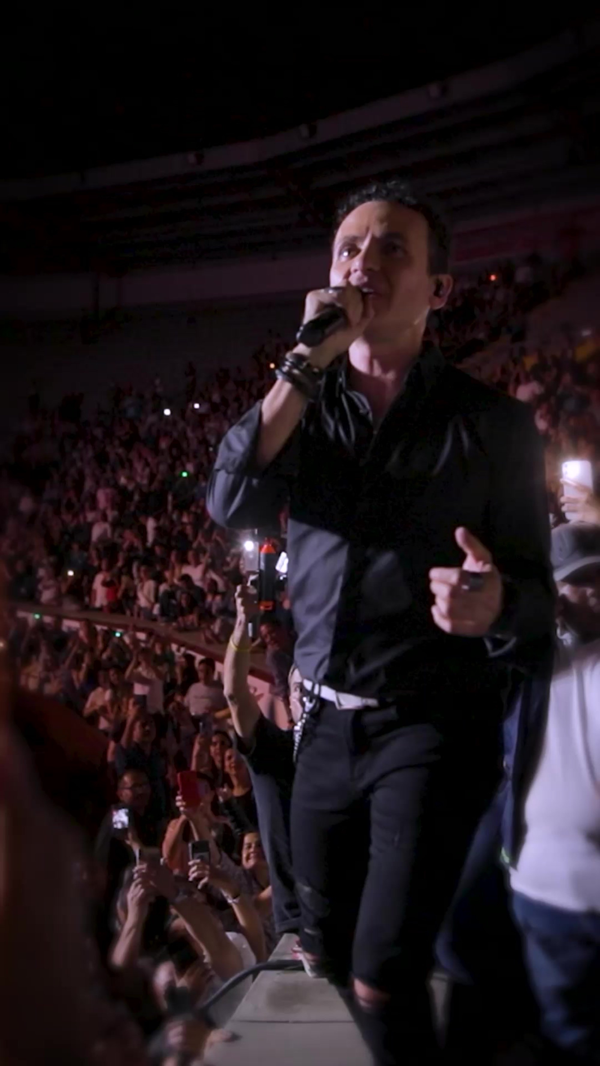 Cantante en el escenario del concierto Éxito x Fonseca frente al público que ilumina con sus celulares