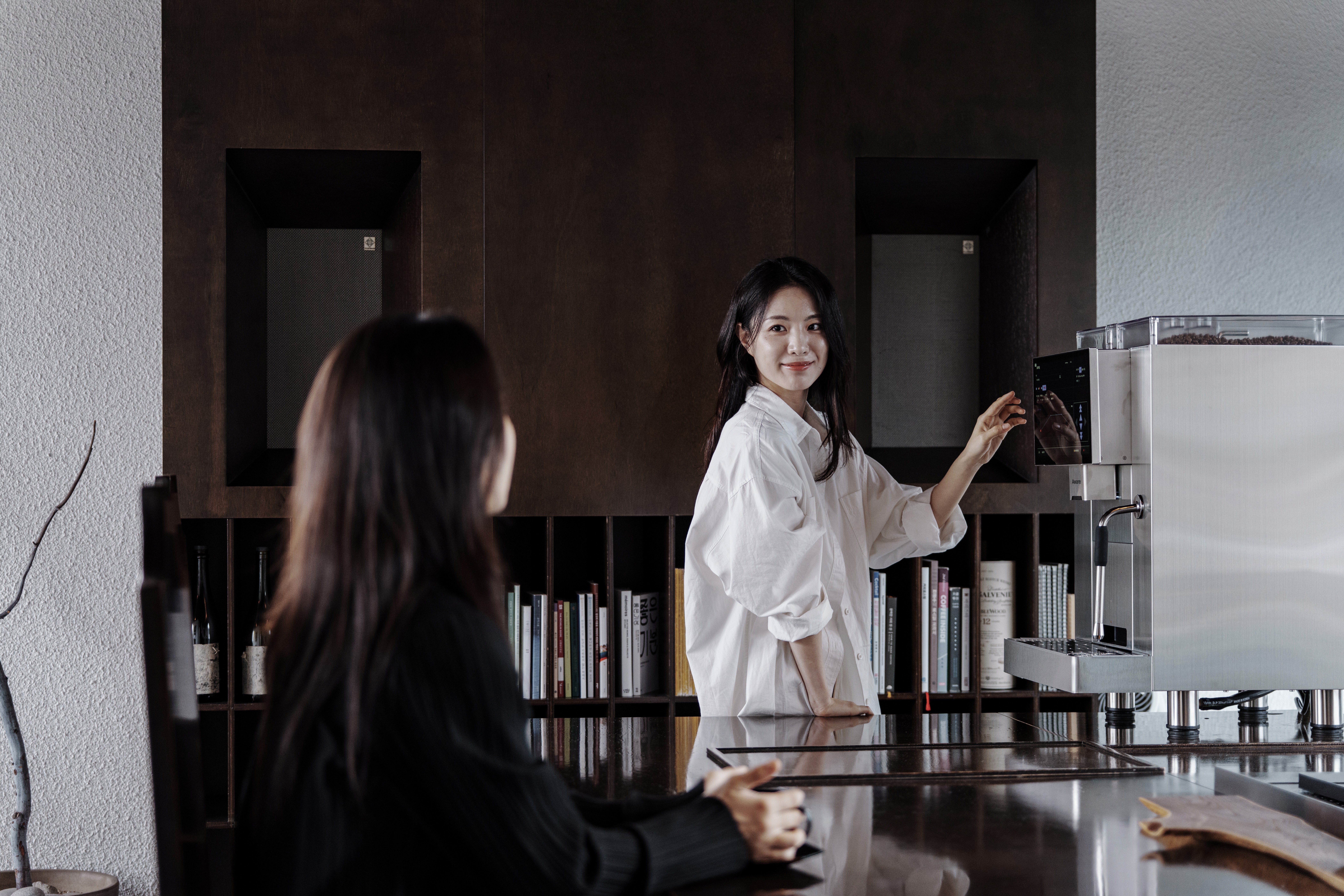 바리스타가 어웨어 머신을 사용하며 손님을 응대하는 모습이다.