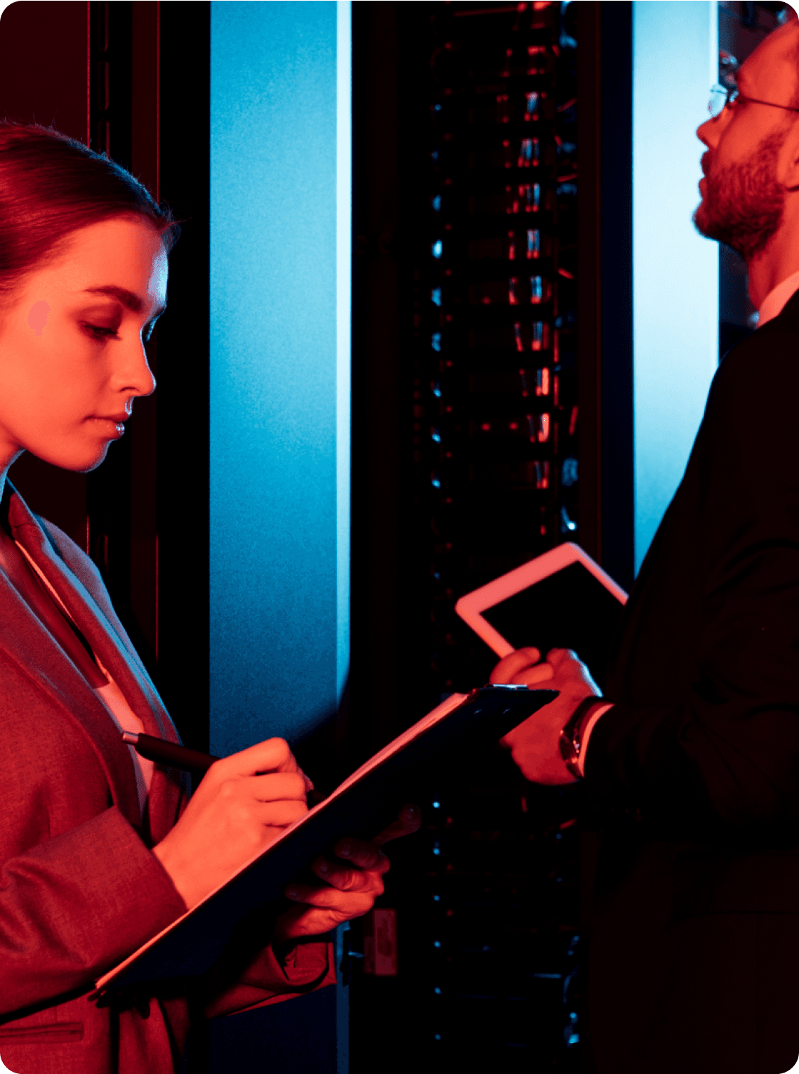 A man and a woman working in a server room 