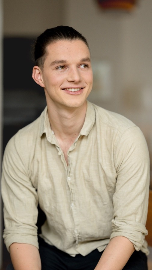 Smiling person seated indoors — founder of Seven Life Areas, offering guidance for living with clarity, harmony, and purpose.