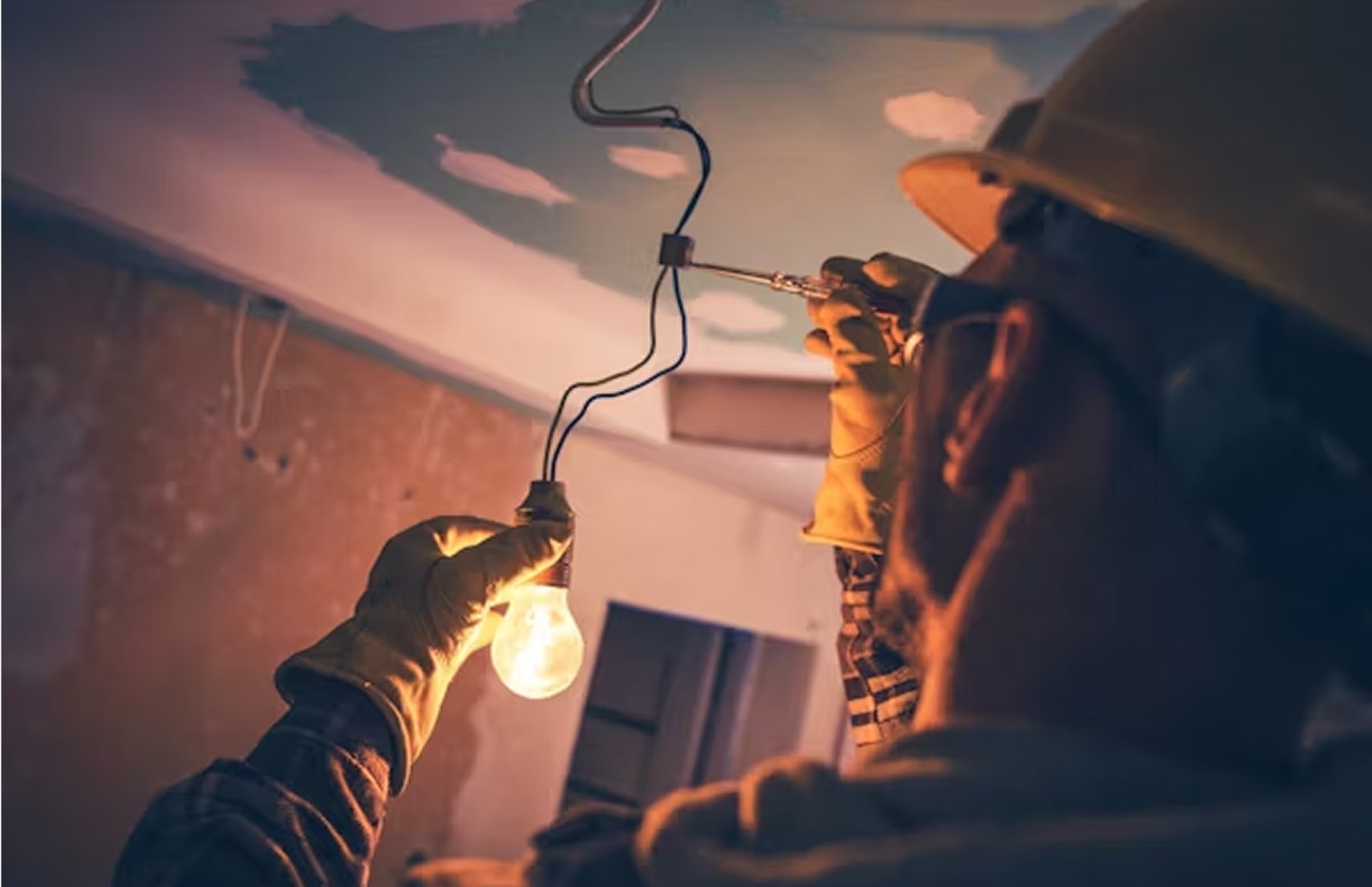A man disconneting the light switch.