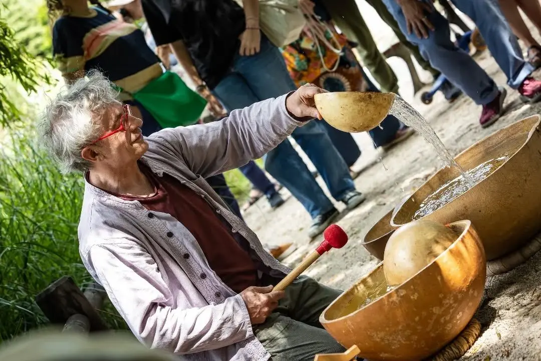 Un homme joue avec des calebasses d'eau pendant un festival.