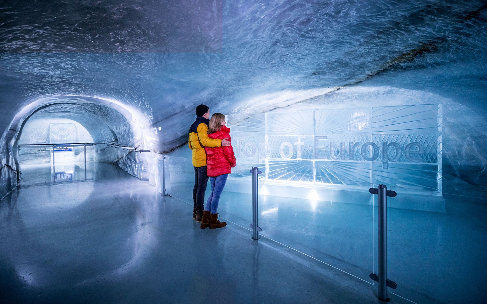 Couple exploring ice tunnel at Jungfraujoch, Switzerland.