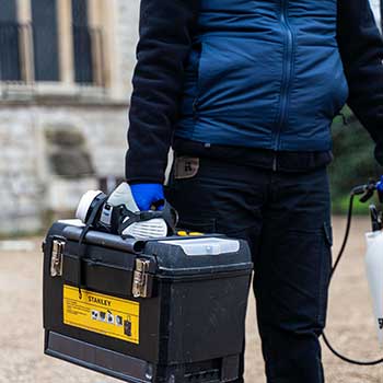 Pest Control Technician holding a box of equitment for proper pest control