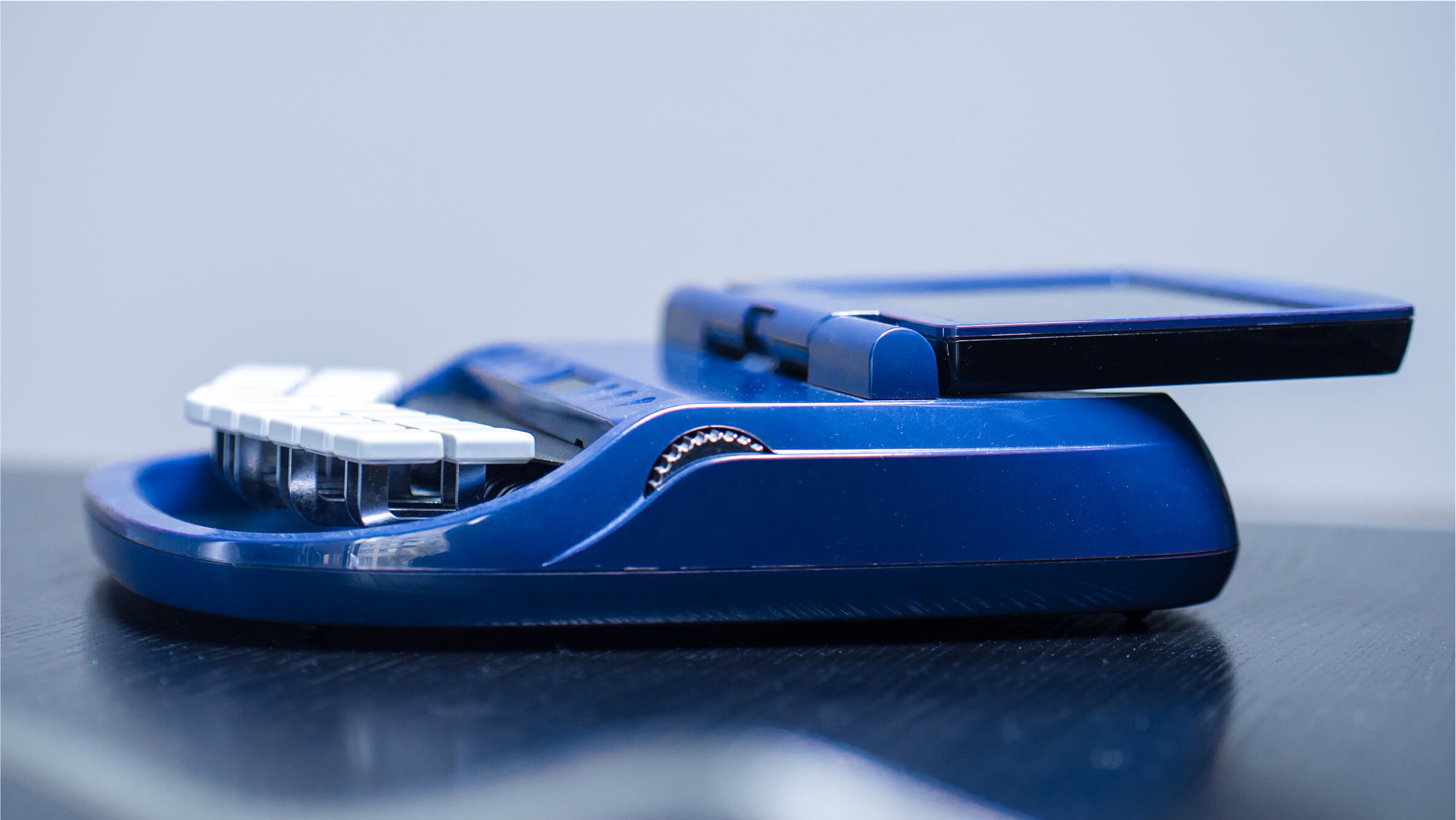 Machine de sténotypie bleue avec écran ouvert, utilisée pour la transcription en temps réel