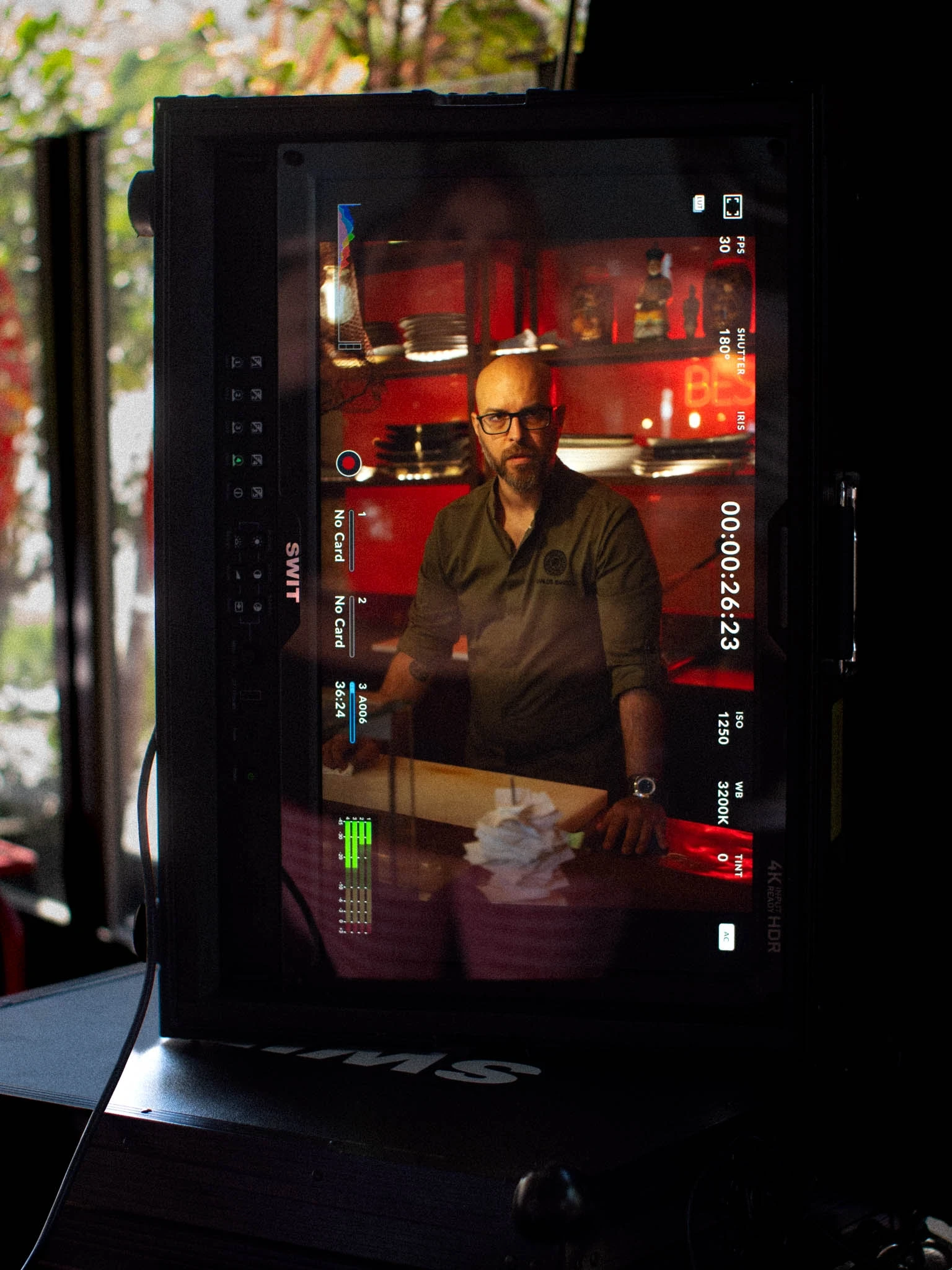 Behind the scenes: camera monitor framing a man at the Soão counter during the Uber Eats shoot