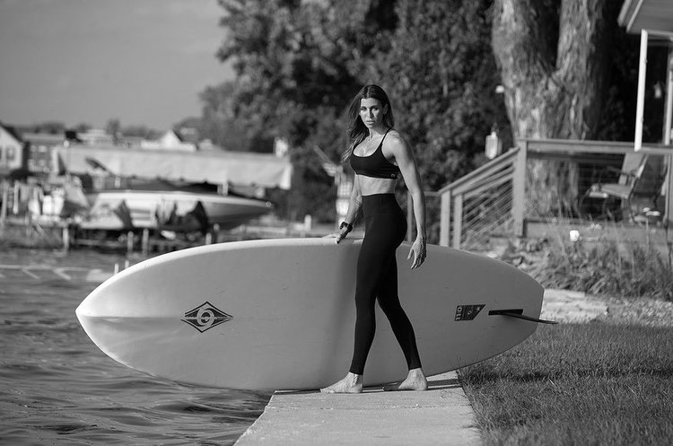 Gym Instructor holding a paddleboard in Achor Fitness Pewaukee.