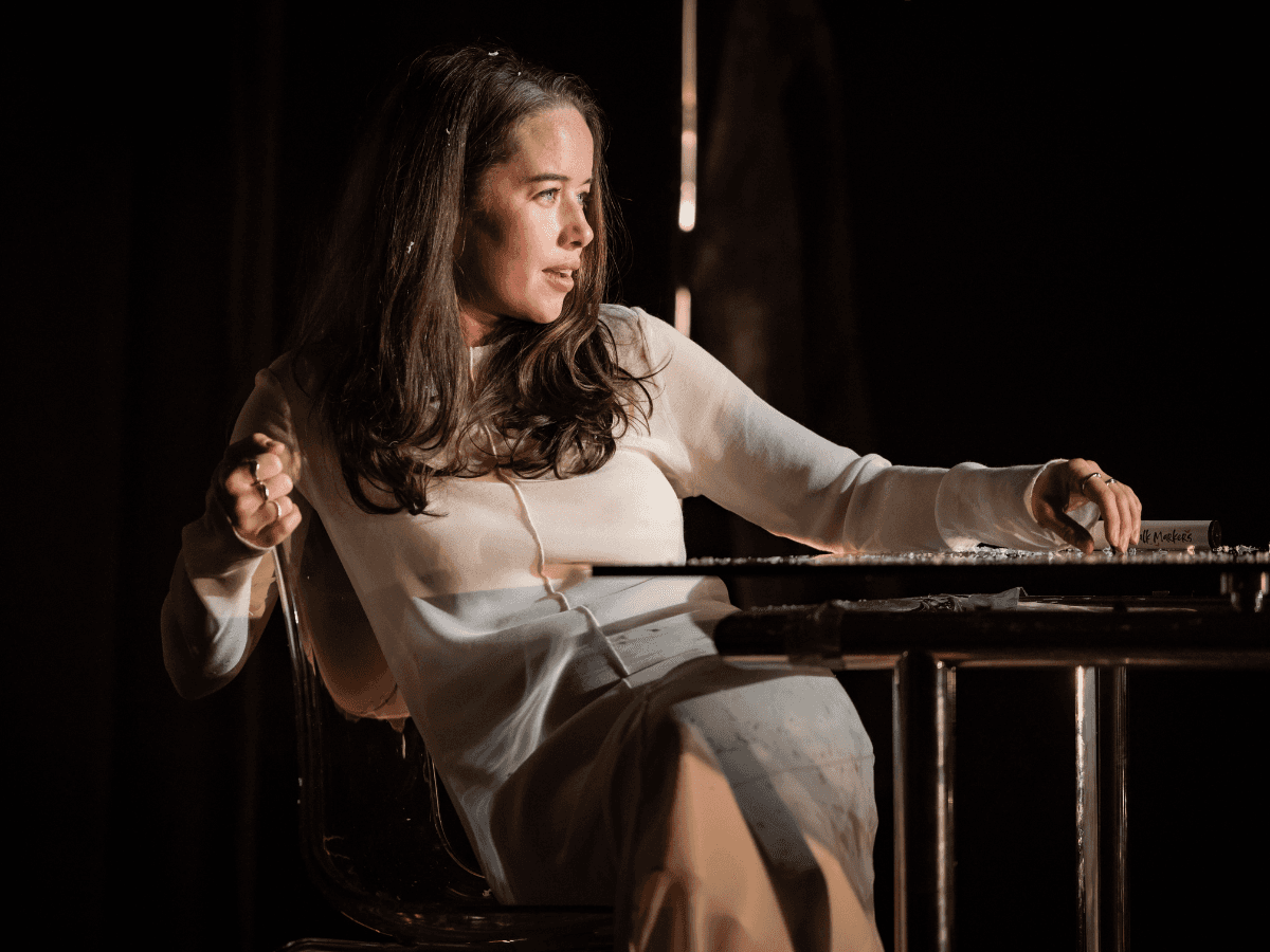 Woman leaning back at a table in a tense, reflective scene from The Wanderers.