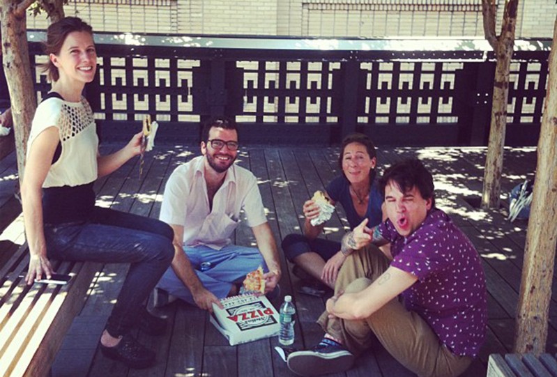 class photo of students eating pizza