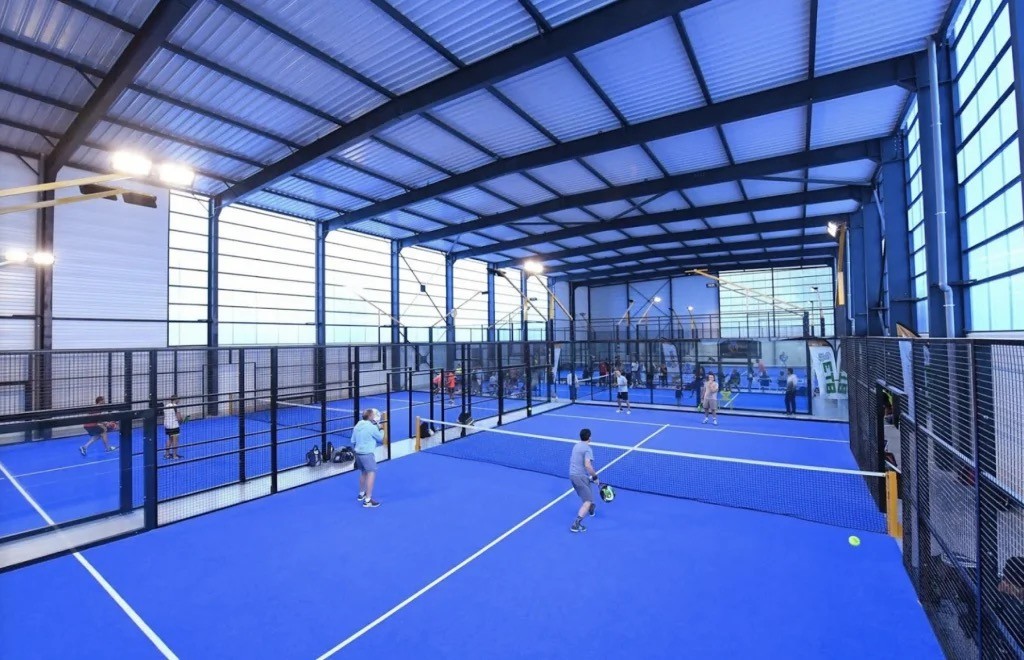 A man holding a tennis racquet on top of a tennis court
