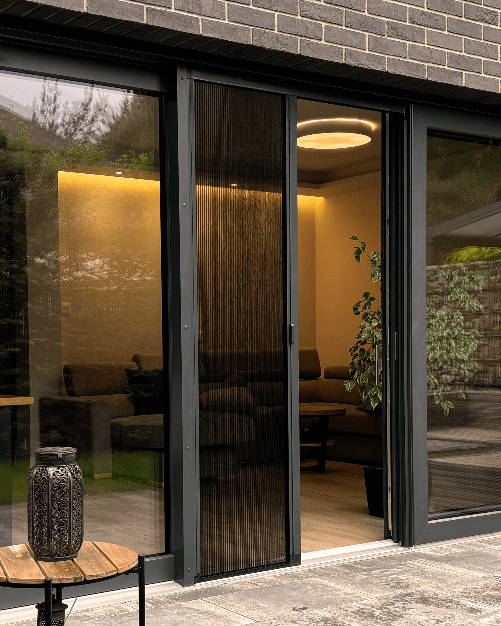 Czarna moskitiera plisowana na dużych przeszkolonych drzwiach tarasowych. HeyShade Pruszków – estetyczna ochrona przed owadami do domów i apartamentów