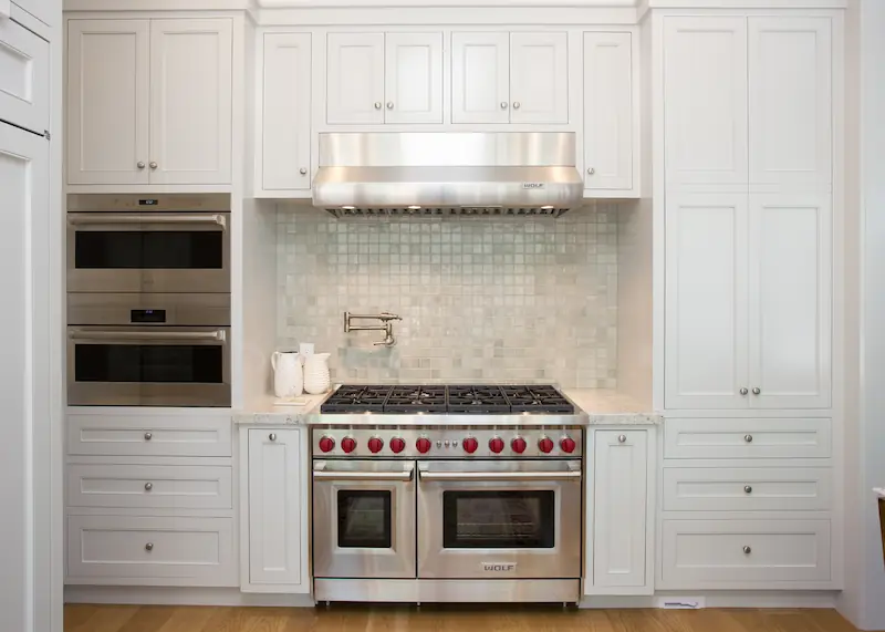 Wolf double oven and range with tile backsplach, wall-mounted pot filler, custom cabinetry and Wolf steamer from the Big Canyon Remodel project. Photo by Chris Darnall.