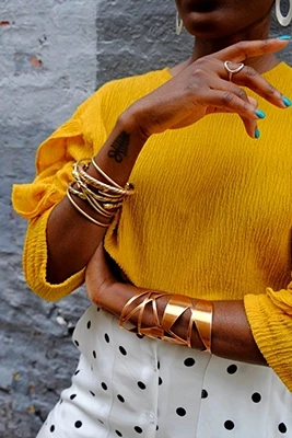 closeup of woman wearing chunky gold bracelets