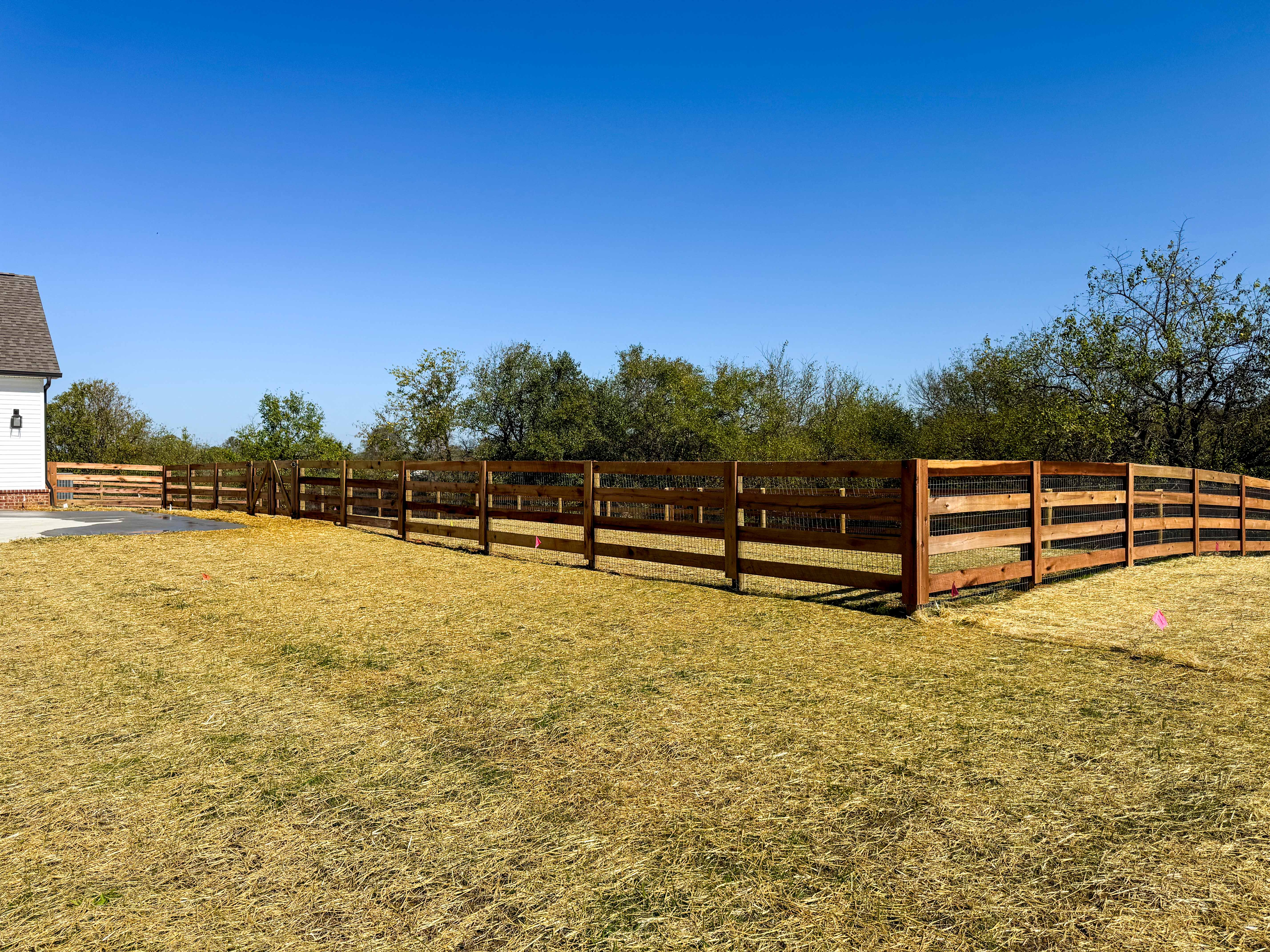 Three rail wood fence installation with wire mesh in Kentucky