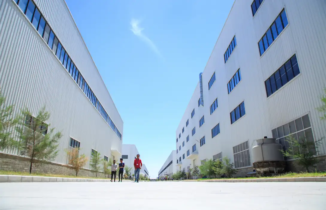 Contemporary textile factory complex with spacious industrial buildings, organized infrastructure, and apparel manufacturing facilities designed for large-scale textile production operations.