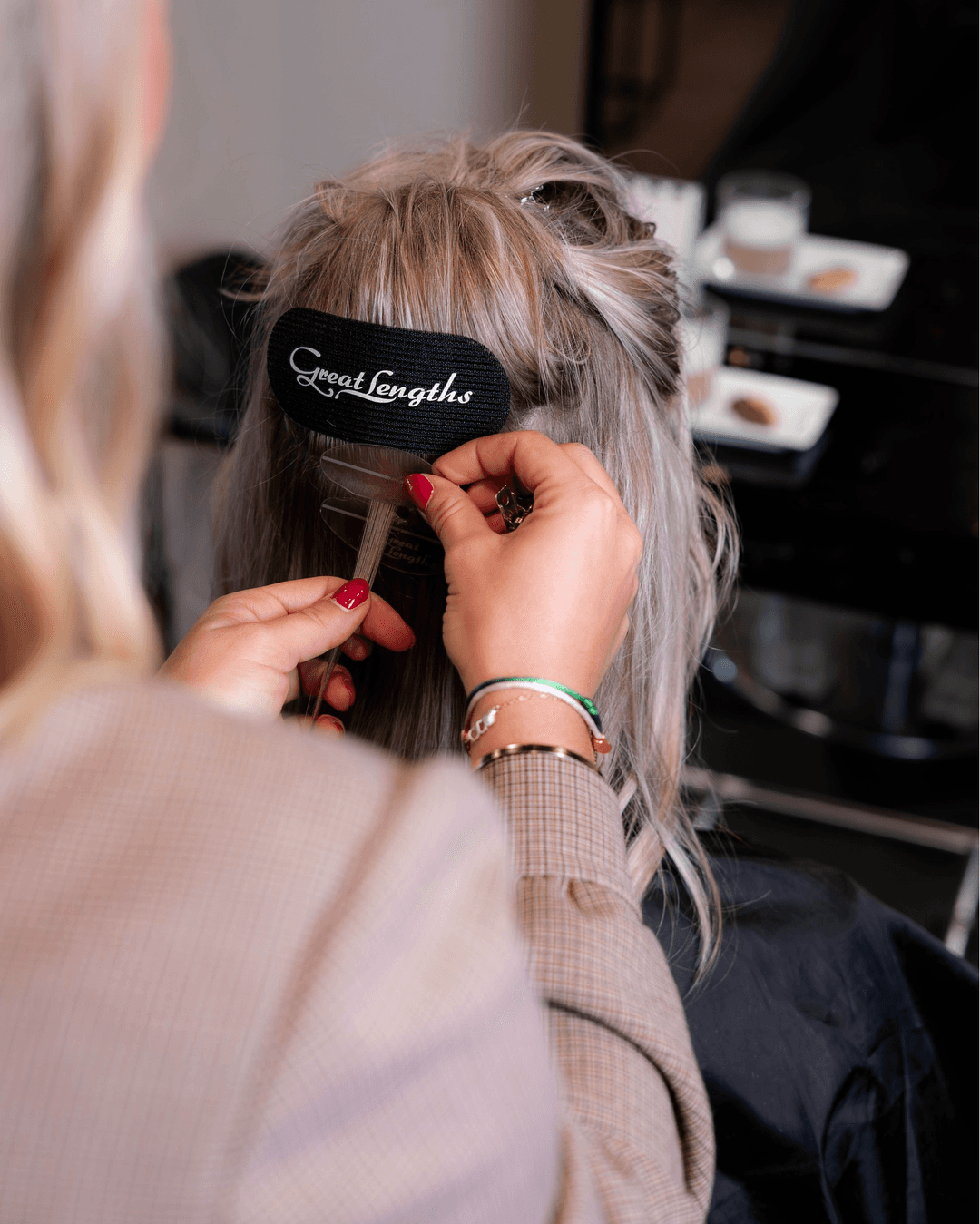 Woman in red outfit poses by a red telephone booth.