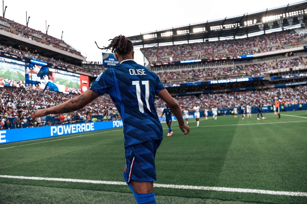 Michael Olise surveys the field from the touchline during France's World Cup match against Iraq