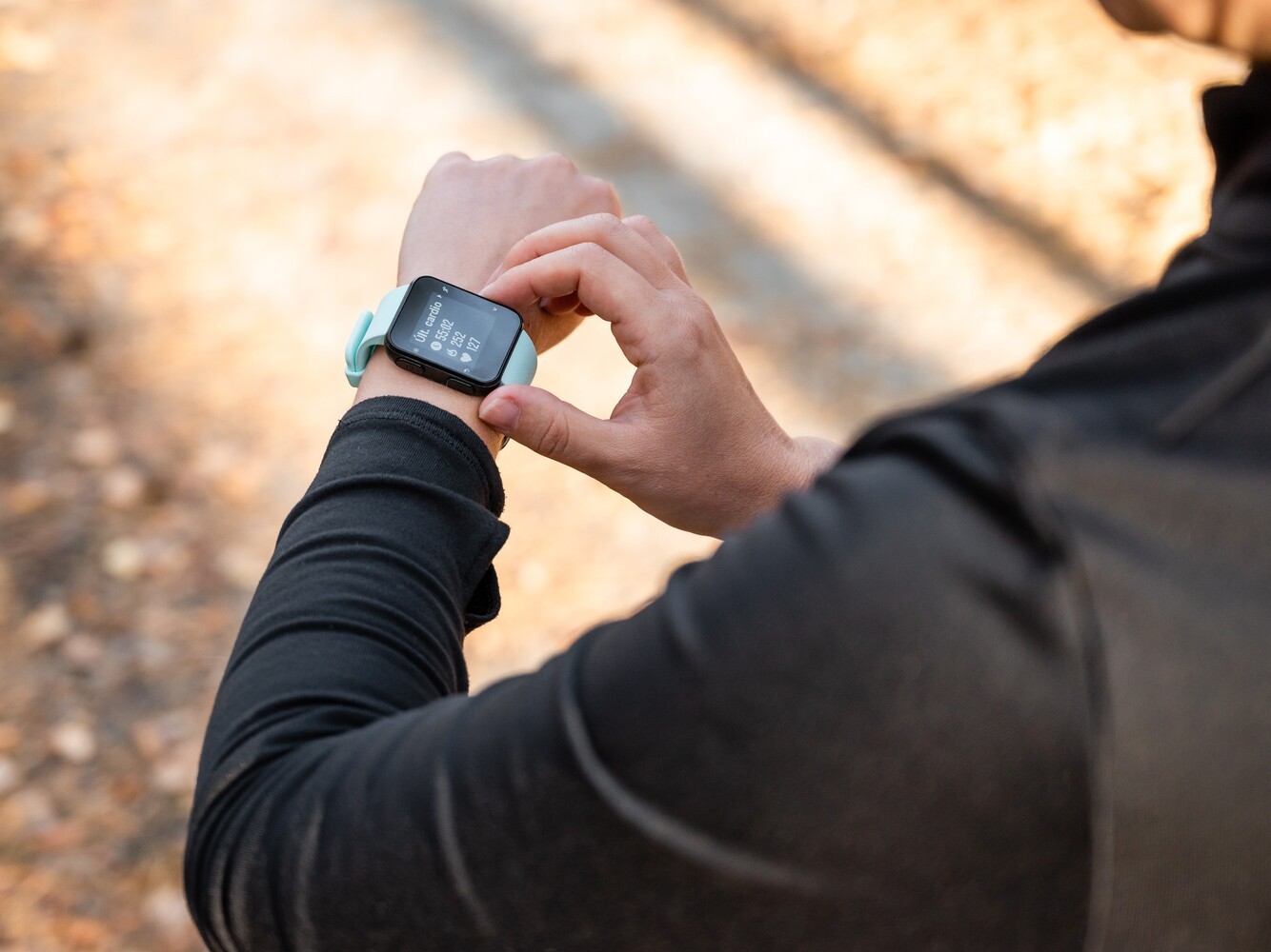 man looking at his fitness tracker to check his heart rate as he follows his weight loss running plan