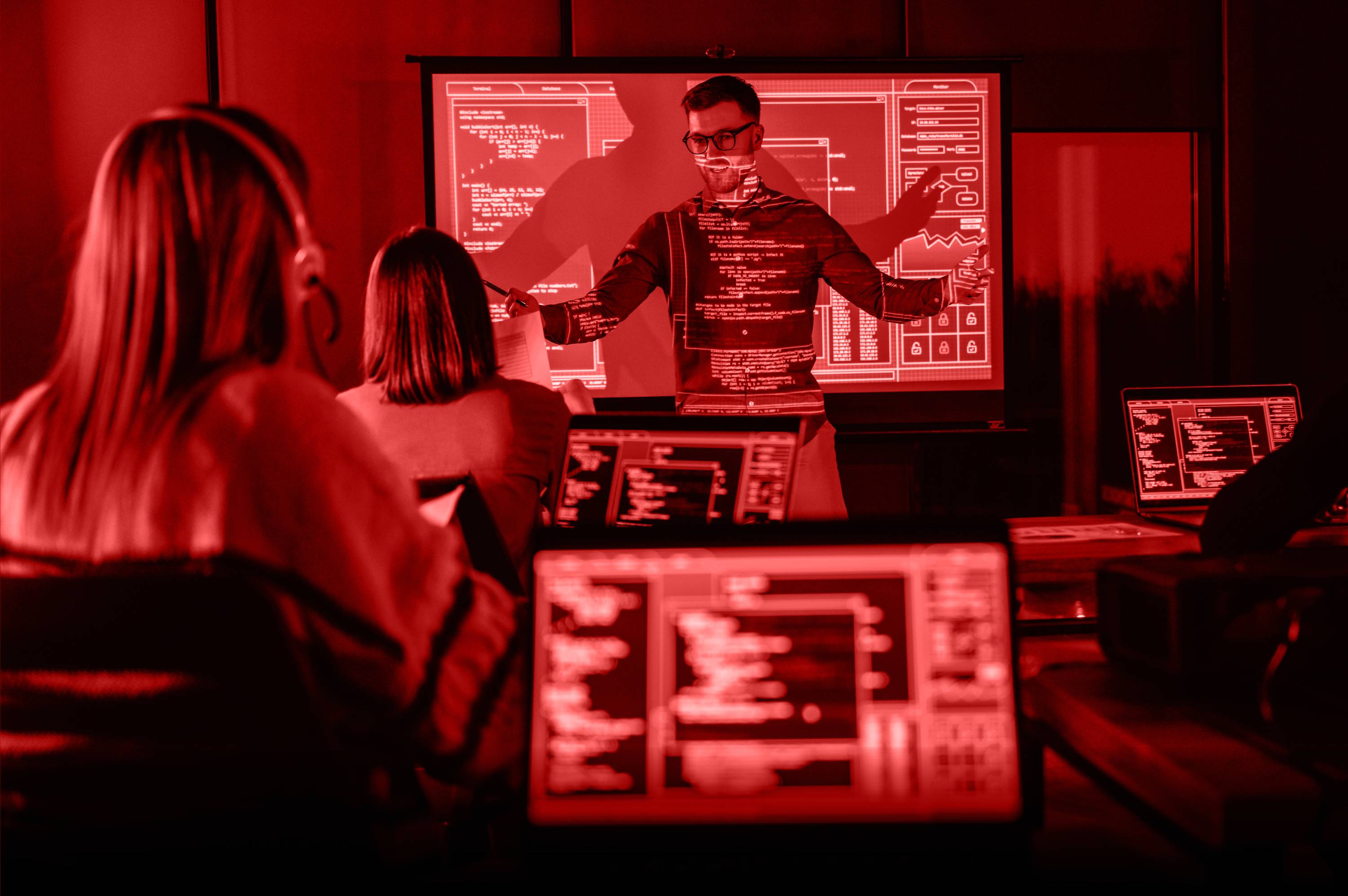 A silhouette of a person interacting with a screen displaying various red data visualizations and graphs.
