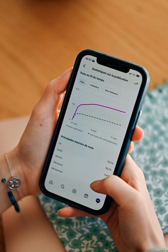 Person using smartphone to view social media analytics.