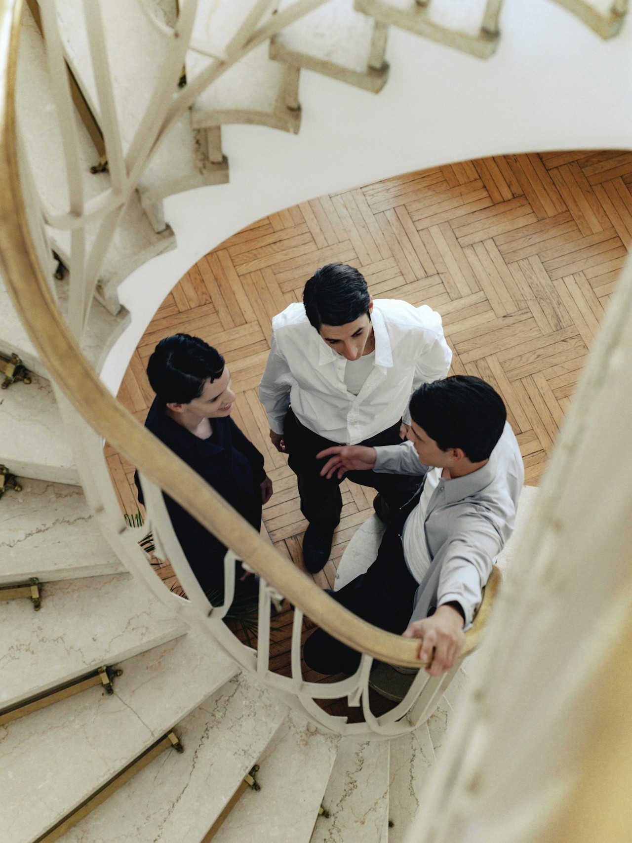 Three friends viewed from above while standing on stairs.