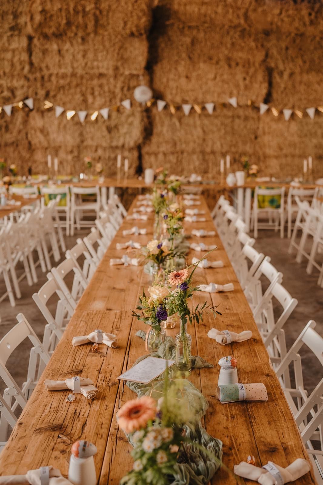Rustikale, handgefertigte Holztische für eine lange Hochzeitstafel – hochwertige Mietmöbel mit floraler Dekoration für ein naturnahes Event