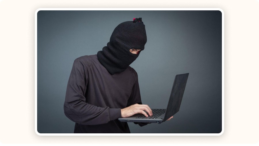 masked person using laptop