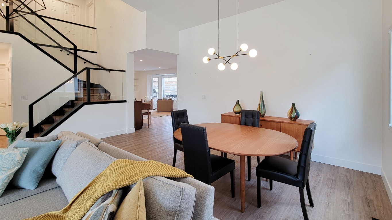 Image of Modern dining room with round wooden table and black chairs, KHD Homes design-build interior layout design.