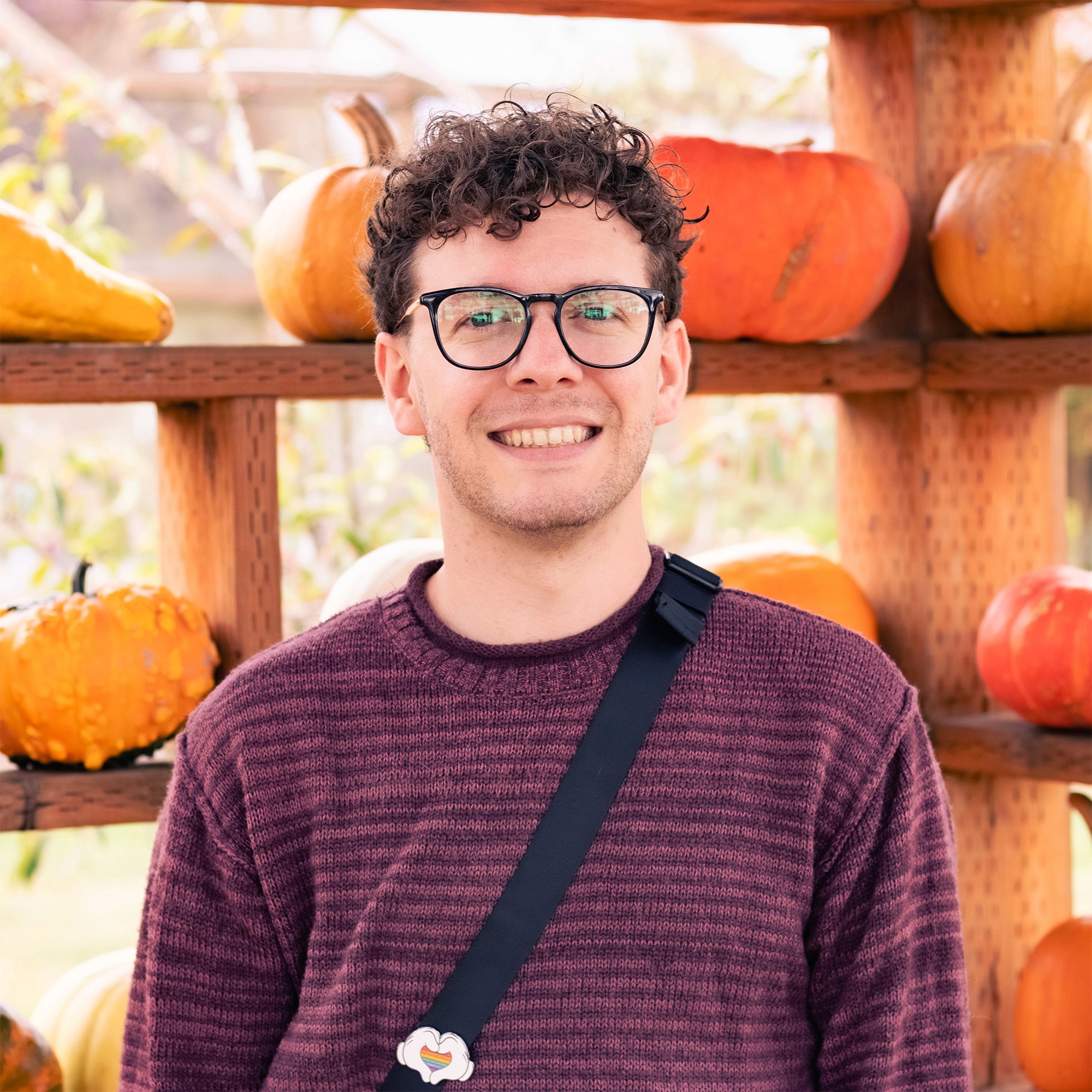 Awkward man standing near pumpkins