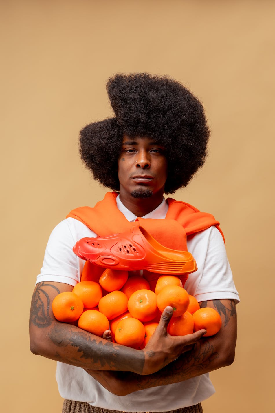 Creative portrait of man holding oranges