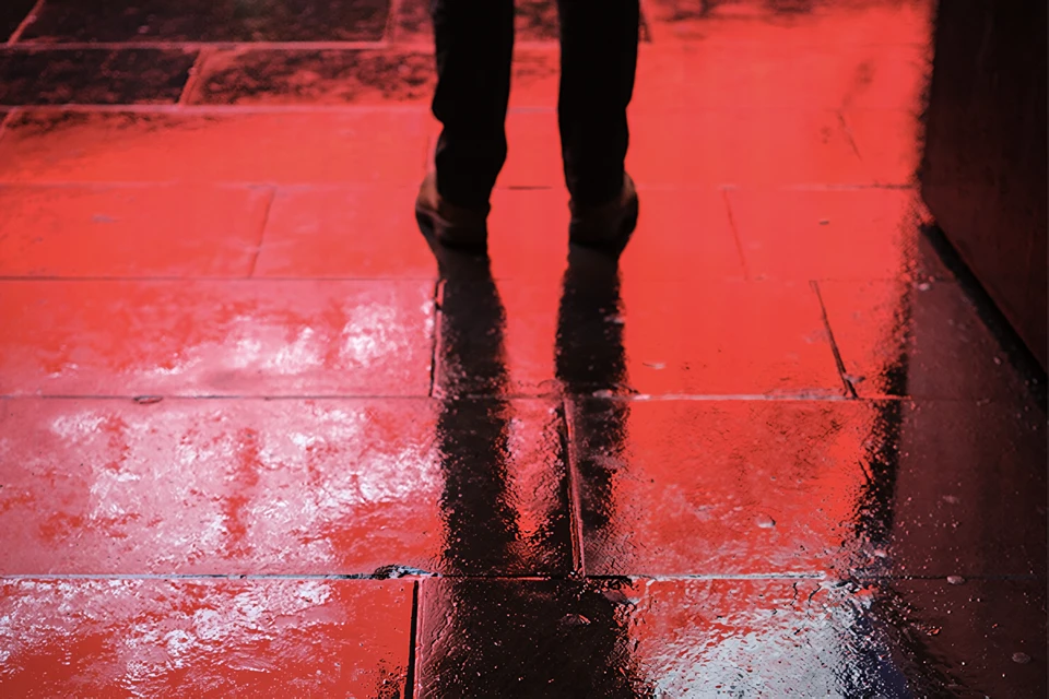 Photograph of red light reflecting on street