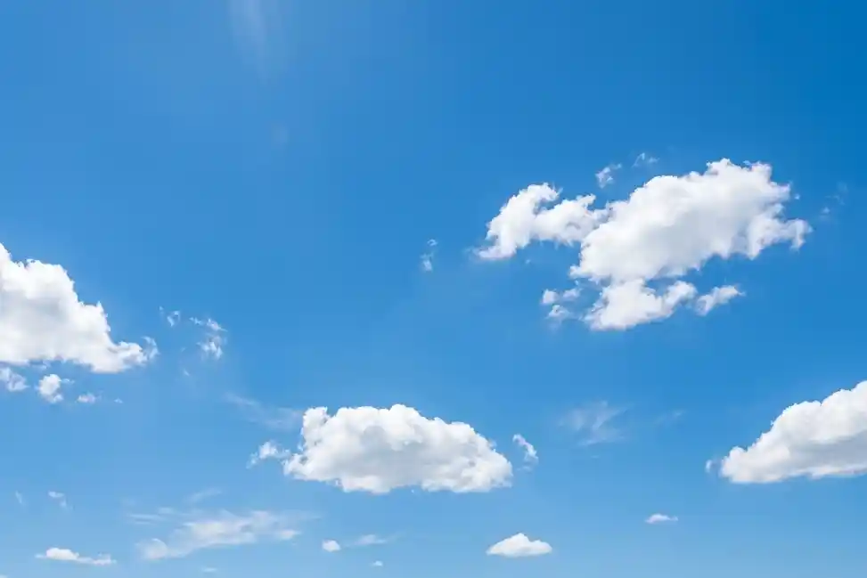 A bright blue sky with clouds